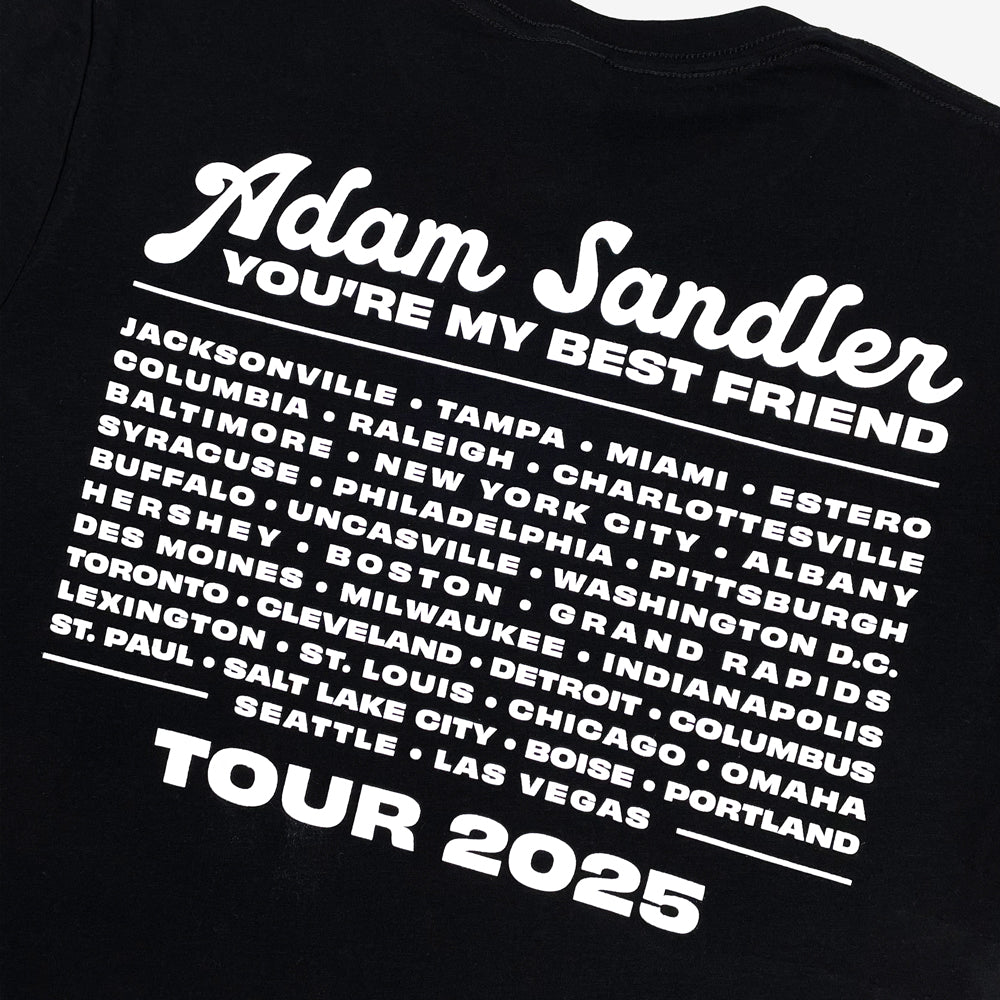 Close up of a black t-shirt with white text listing cities and 'You're My Best Friend' tour details