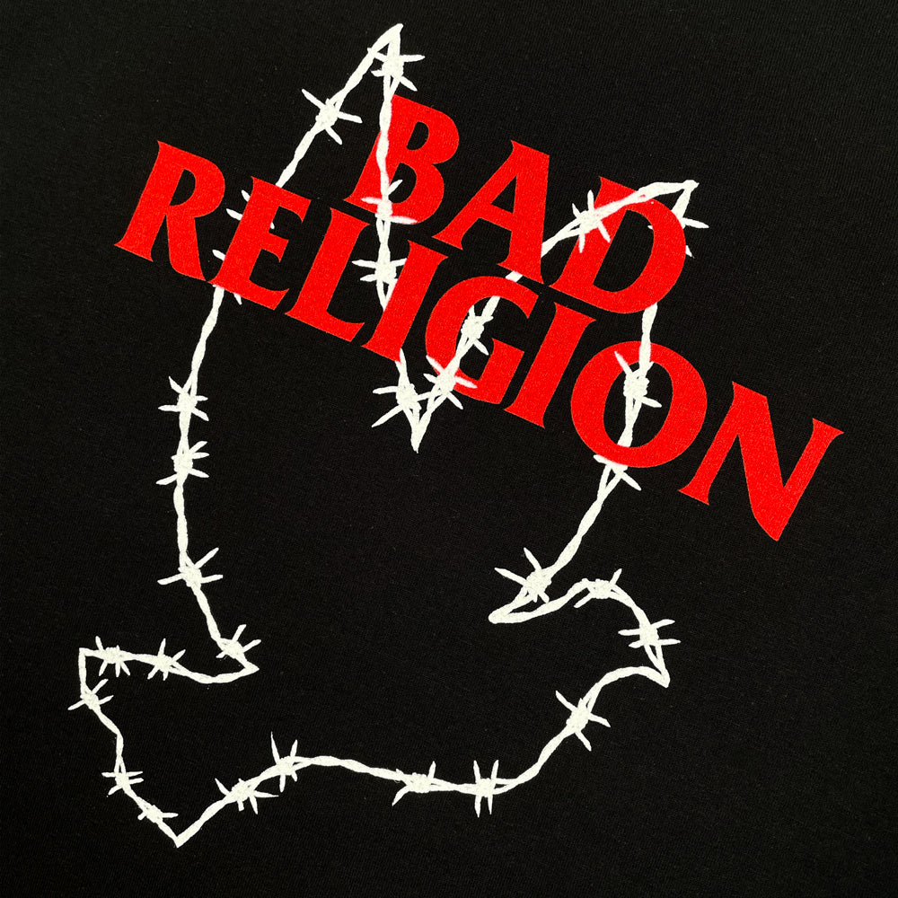 Close up of a black t-shirt with barbed wire dove graphic and red text reading "BAD RELIGION"
