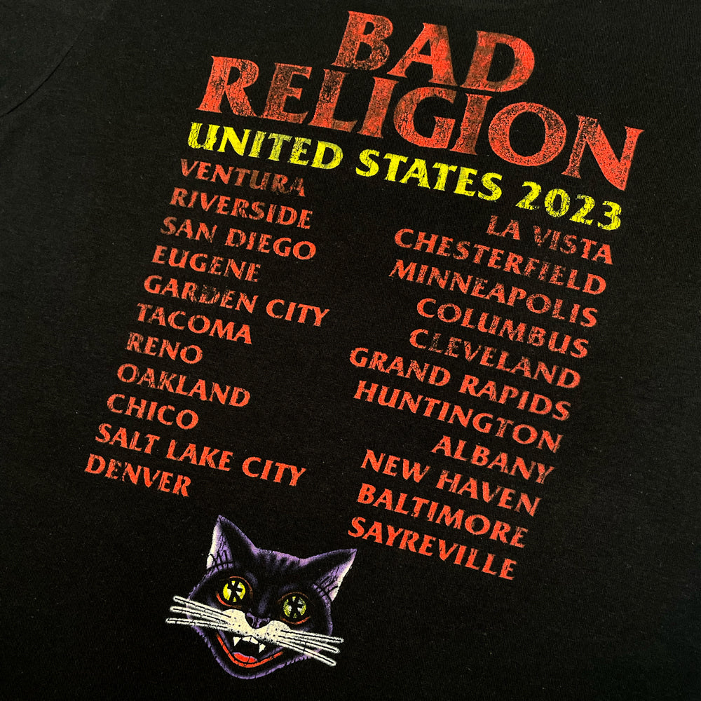Close up of the back print of black Bad Religion tee with lettering reading "Bad Religion United States 2023" followed by list of cities from the 2023 tour.