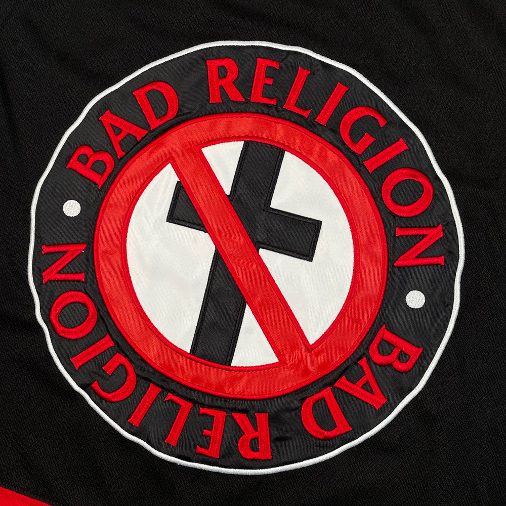 Close up of a black and red hockey jersey with Bad Religion crossbuster logo and text reading "Bad Religion Bad Religion"