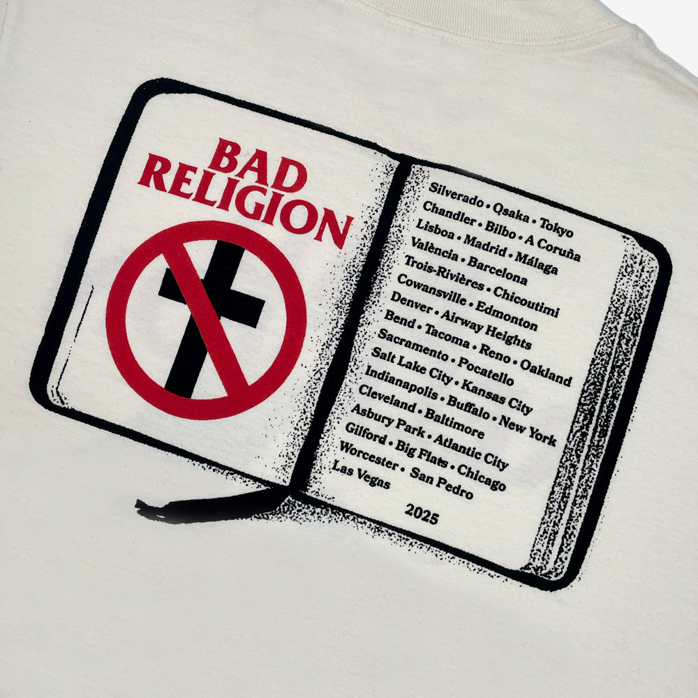Close up of a cream t-shirt with graphic of a book displaying text reading "BAD RELIGION" followed by a list of cities from the 2025 tour against a white background