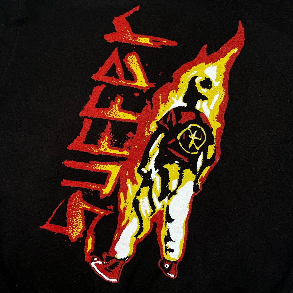Close up of a black Bad Religion sweatshirt back print with graphic of a man on fire next to the word "SUFFER"