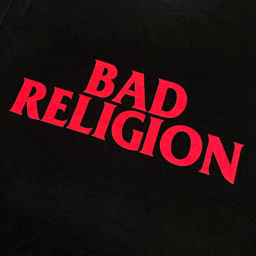 Close up of a black Bad Religion t-shirt front print with red text reading "BAD RELIGION"