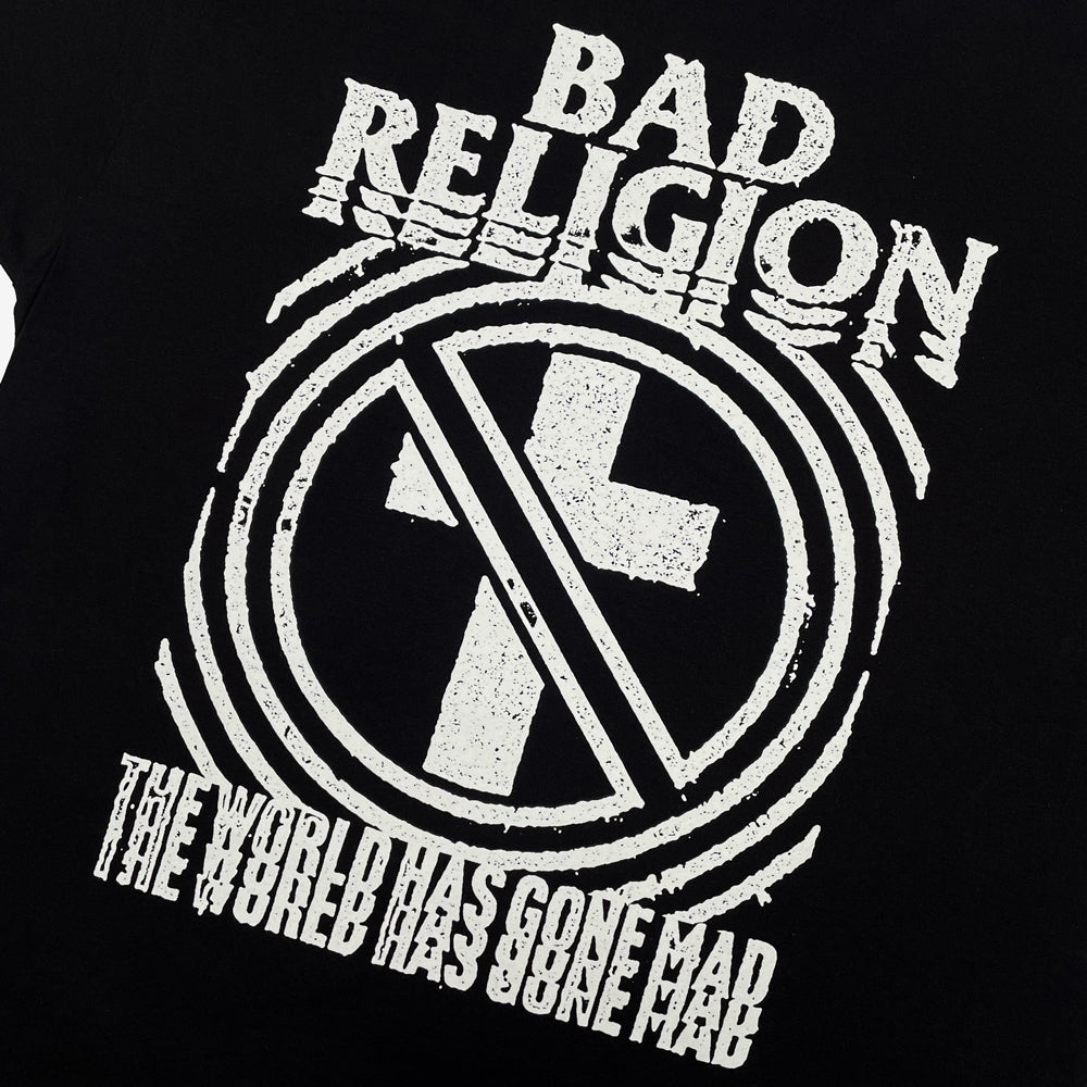 Close up of a black t-shirt with white Bad Religion crossbuster logo nd text reading "BAD RELIGION THE WORLD HAS GONE MAD"