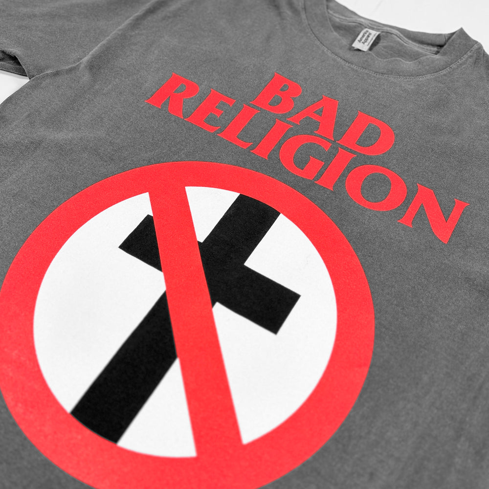 Close-up of red Bad Religion lettering and the red, white, and black crossed-out cross graphic on faded black fabric.