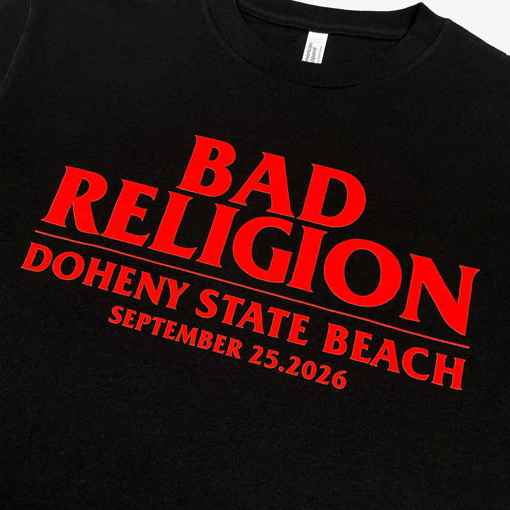 Close up of the front of a black tee against a white background with red text reading "Bad Religion, Doheny State Beach, September 25,2026"
