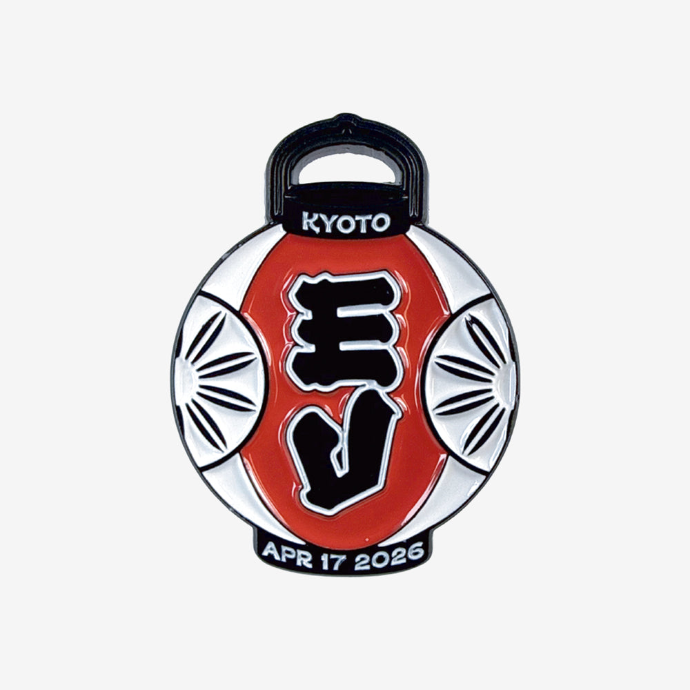 An enamel pin against a white background that is a design of a white and red Japanese decorative lantern. In white text at the top it reads "Kyoto" and at the bottom it reads in white text "Apr 17 2026"
