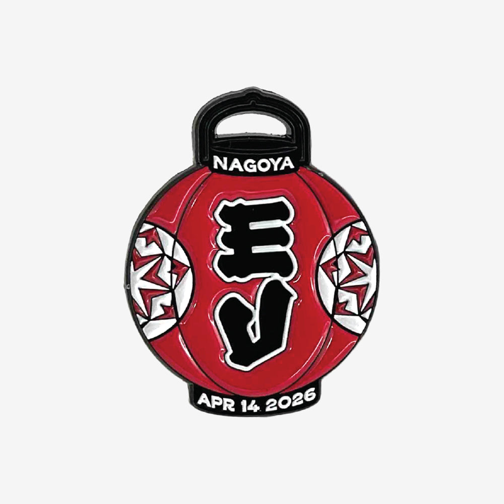 An enamel pin against a white background that is a design of a red Japanese decorative lantern. In white text at the top it reads "Nagoya" and at the bottom it reads in white text "Apr 14 2026"
