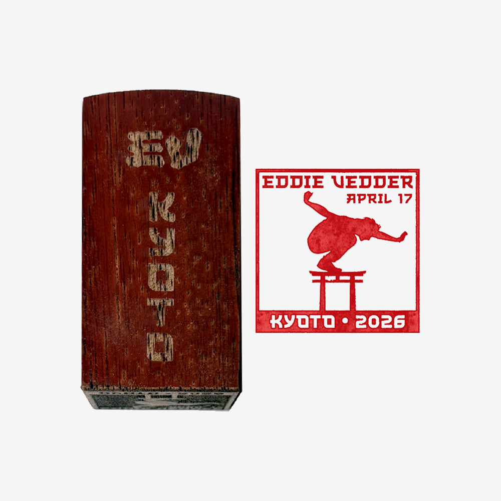 Wood stamp against white background with text that reads "EV Kyoto" and to the right is a red stamp of a man balancing on Mt. Fuji with text that reads "Eddie Vedder April 17, Kyoto 2026"
