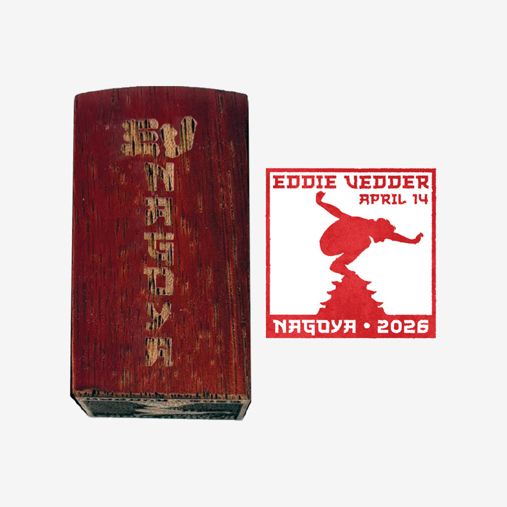 Wood stamp against white background with text that reads "EV Nagoya" and to the right is a red stamp of a man balancing on Mt. Fuji with text that reads "Eddie Vedder April 14, Nagoya 2026"