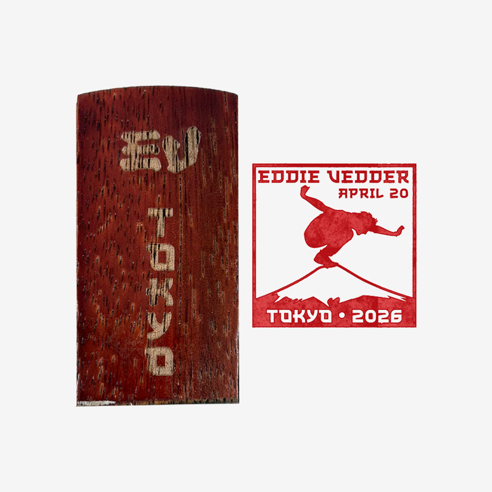 Wood stamp against white background with text that reads "EV Tokyo" and to the right is a red stamp of a man balancing on Mt. Fuji with text that reads "Eddie Vedder April 20, Tokyo 2026"