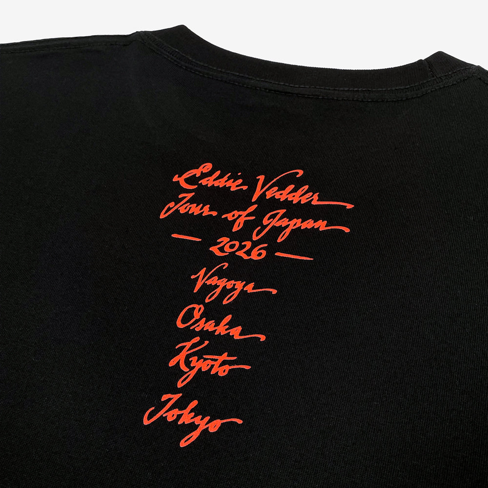 Close up of the back of a black T shirt against a white background with red text reading "Eddie Vedder, Tour of Japan, 2026, Nagoya, Osaka, Kyoto, Tokyo"