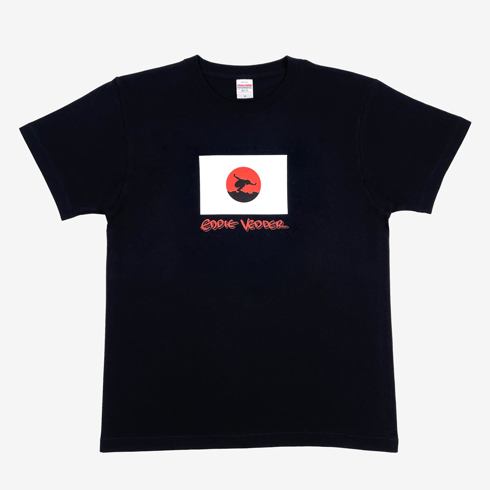 Black T shirt against a white background with a design of Japanese flag and a silhouette of a person posing in the center. Below the flag design in a red text design that reads "Eddie Vedder"