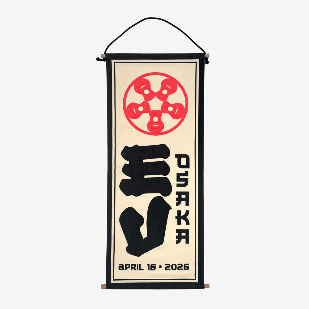 A wall scroll against a white background. At the top of the scroll is a light red circular design. In the middle is large black text reading "EV" and to the right of that is black text reading "Osaka" At the bottom in black text there is a date that reads "April 16, 2026"