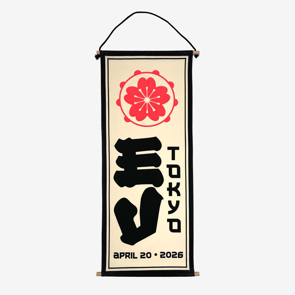 A wall scroll against a white background. At the top of the scroll is a light red circular design. In the middle is large black text reading "EV" and to the right of that is black text reading "Tokyo" At the bottom in black text there is a date that reads "April 20, 2026"