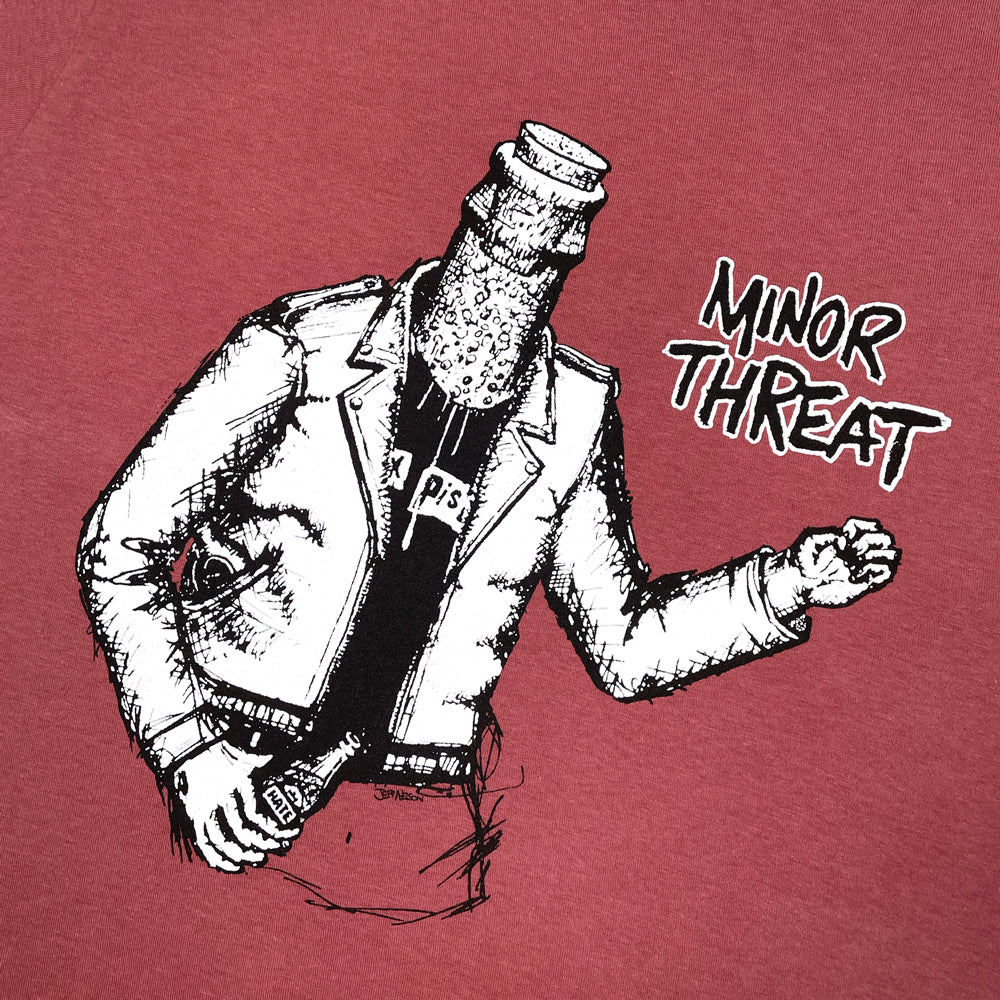 Close up of a terracotta Minor Threat Tee with bottle graphic next to the words "MINOR THREAT"