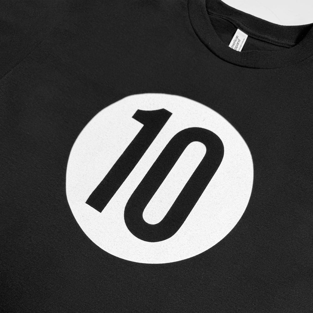 Close-up of the black number 10 inside a white circle on the black Ohana 10 Tee.