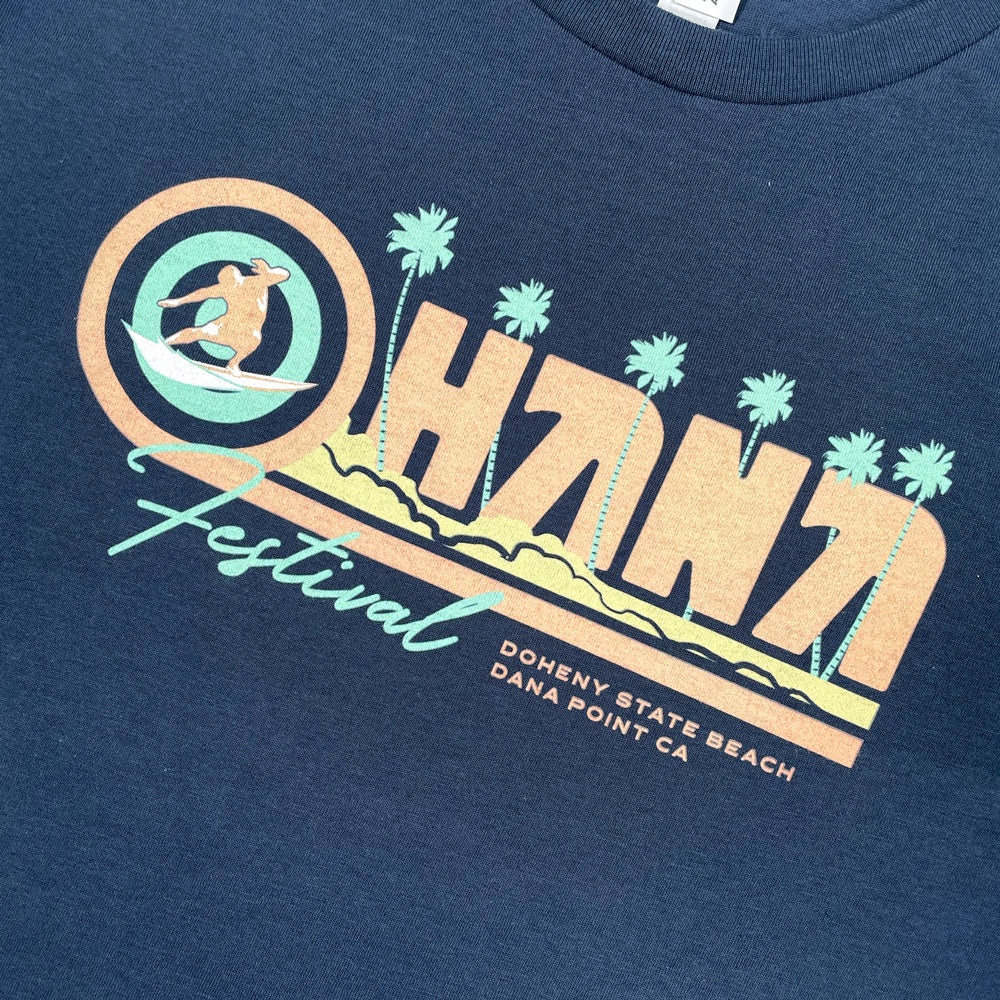 Close up of a navy Ohana Festival t-shirt from the front displaying graphic lettering which reads "Ohana Festival Doheny State Beach Dana Point CA"