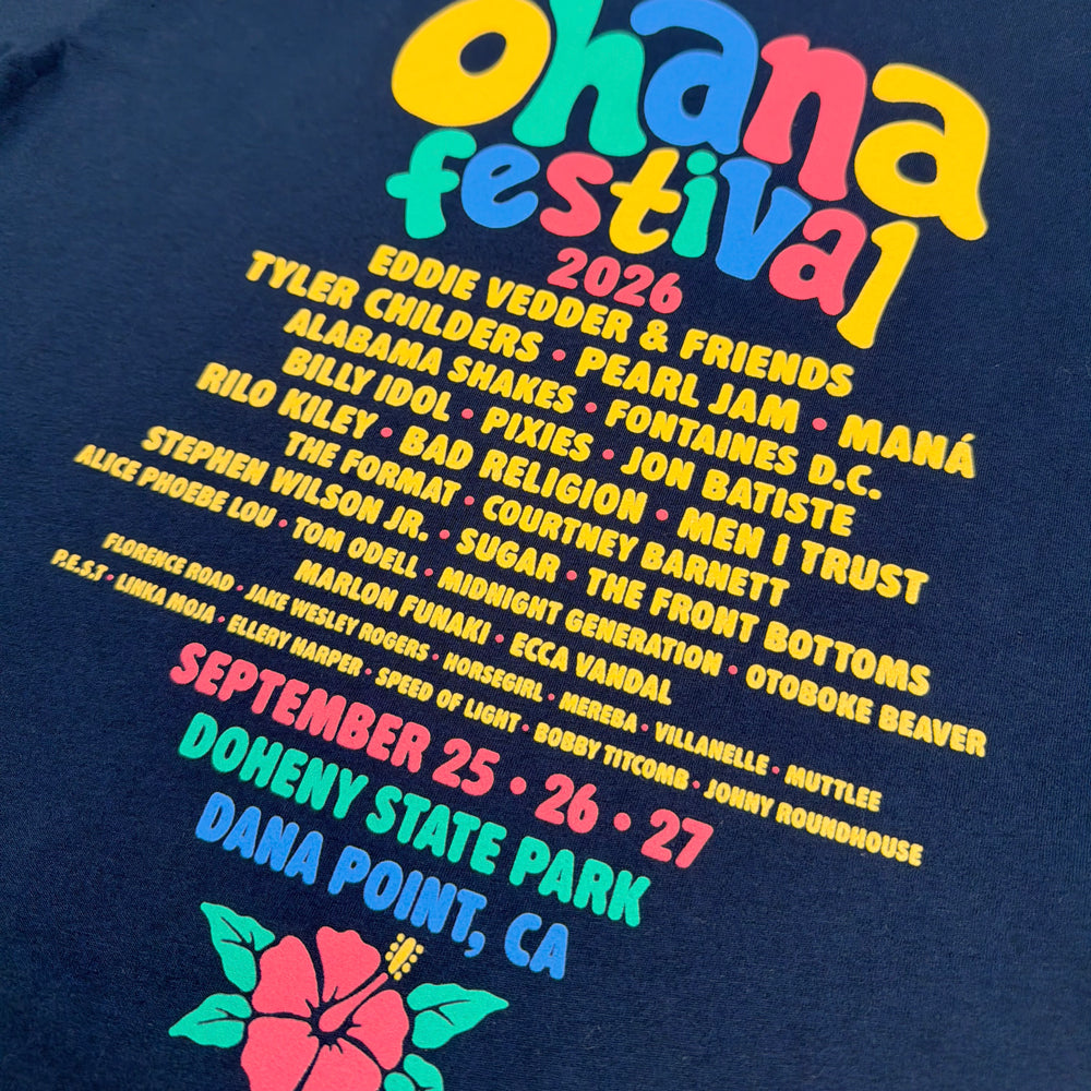 Close-up of the artist lineup, colorful event details, and hibiscus on the navy Bubble Letters Tee’s back.