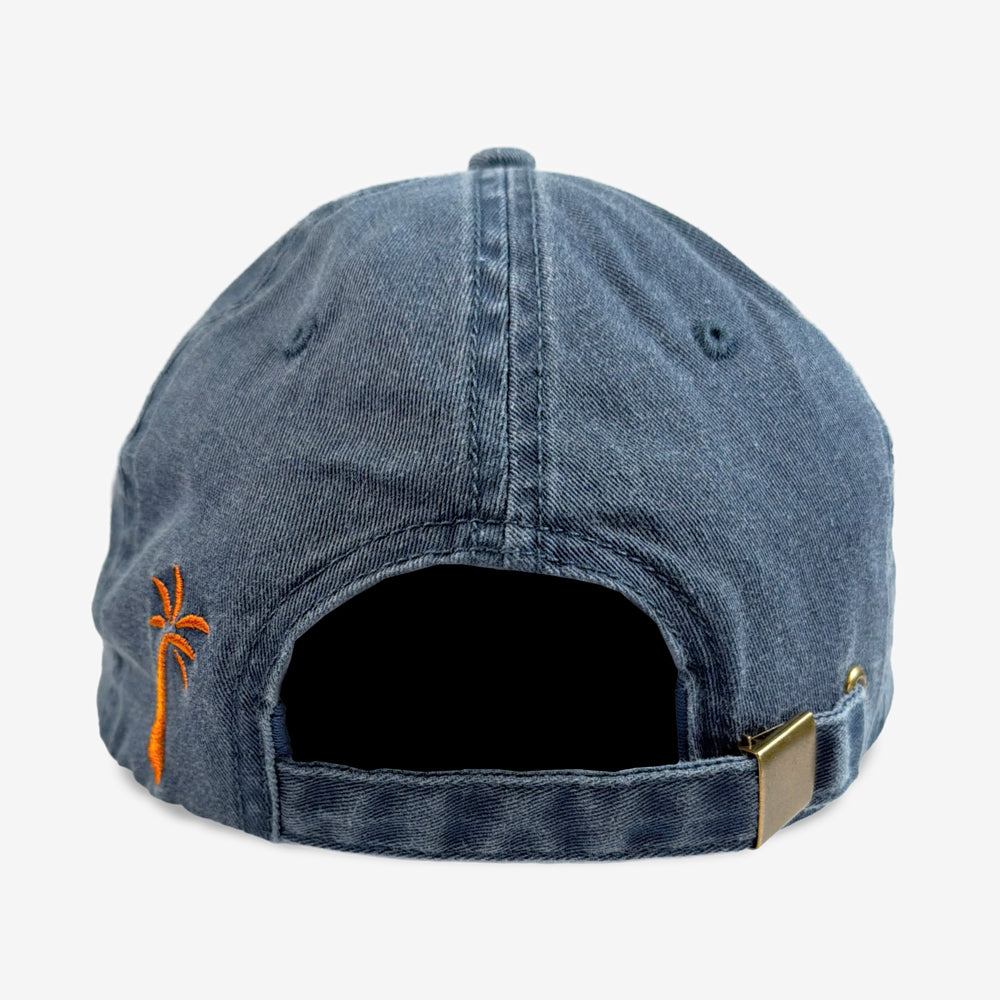 Back of the washed navy Ohana Drop In Hat with an orange palm tree detail and an adjustable buckle strap.