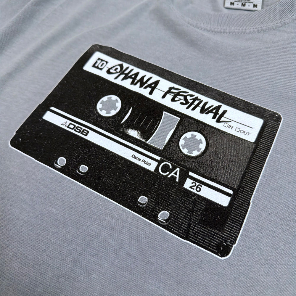 Close-up of the cassette graphic with Ohana Festival lettering and CA 26 details on the granite-gray tee.