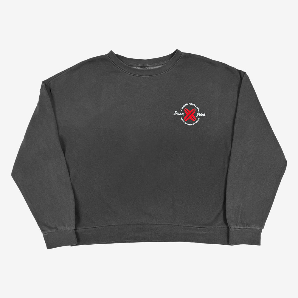 A dark gray crewneck sweatshirt with a small circular graphic on the left chest featuring red crossed surfboards and white text that reads "Ohana Festival, Dana Point, September 27, 2026"