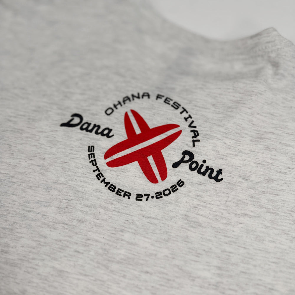 Close-up of red surfboard and Dana Point event graphic on oatmeal Pearl Jam tee