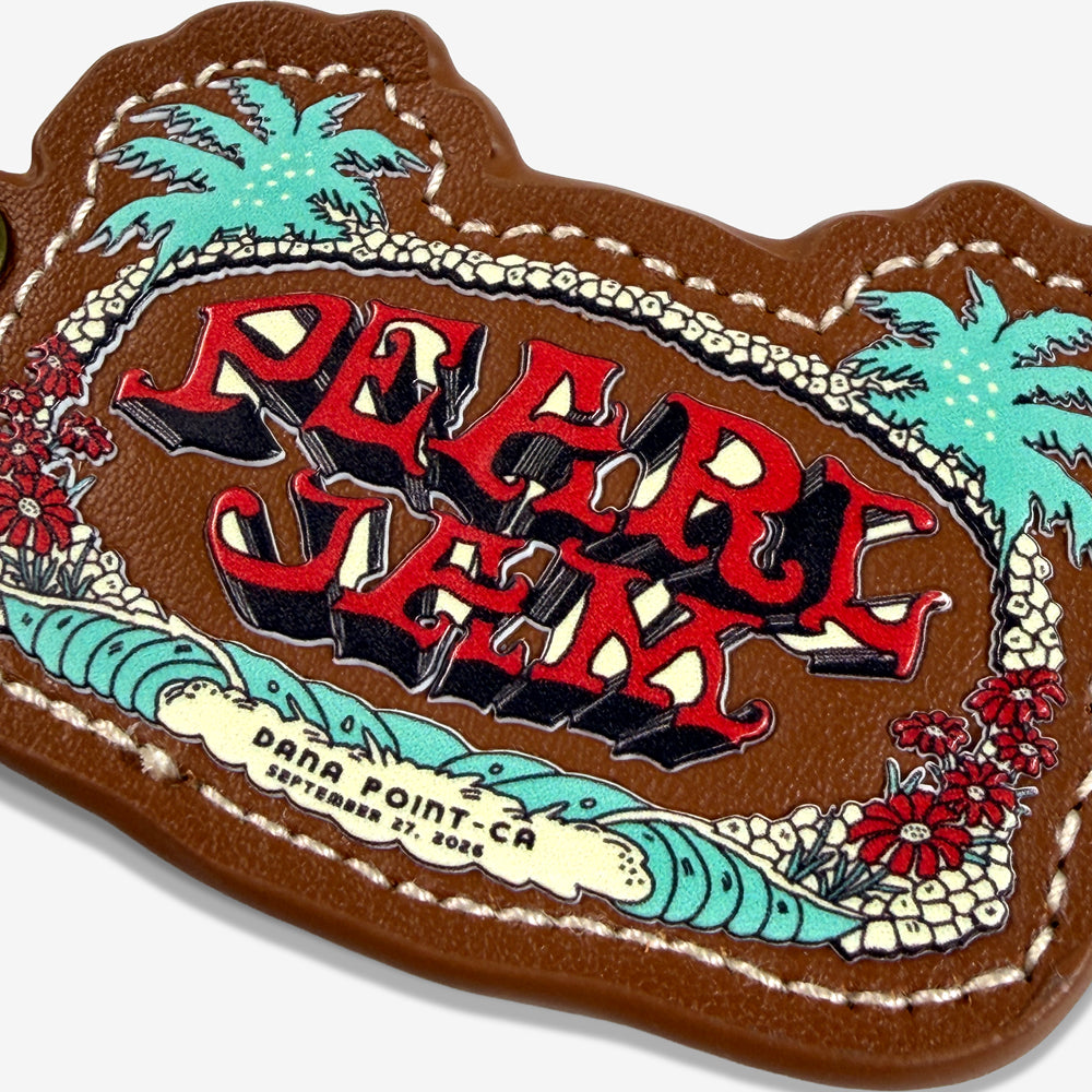 Close-up of Pearl Jam Wild Palms Keychain showing colorful palm tree artwork, ocean waves, and Dana Point September 27, 2026 details.