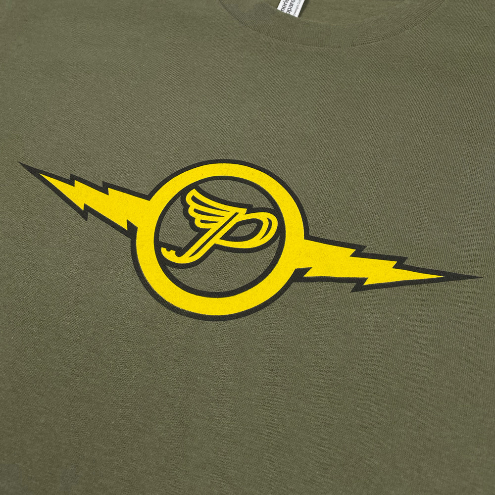 A close up of a military green t shirt featuring a yellow and black Pixies "Circle P" logo with a lightning bolt coming out of both sides.