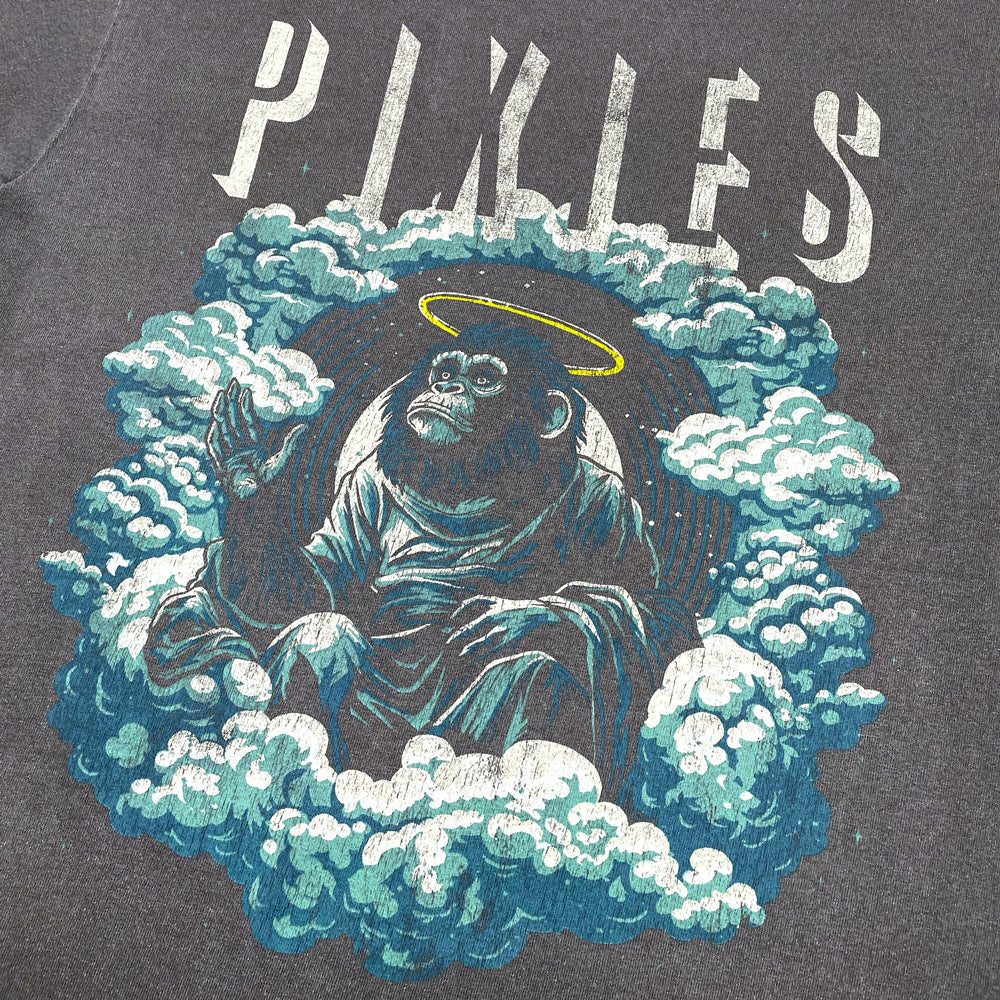 Close up of a faded Black T-Shirt with distressed light gray text reading "Pixies" and a design of an angelic monkey sitting amongst clouds.