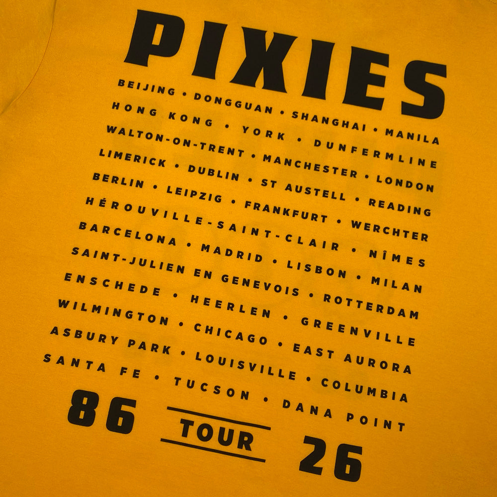 Close up of the back of a yellow Pixies Shirt with black lettering reading Pixies followed by all locations on the Pixies 2026 Tour.