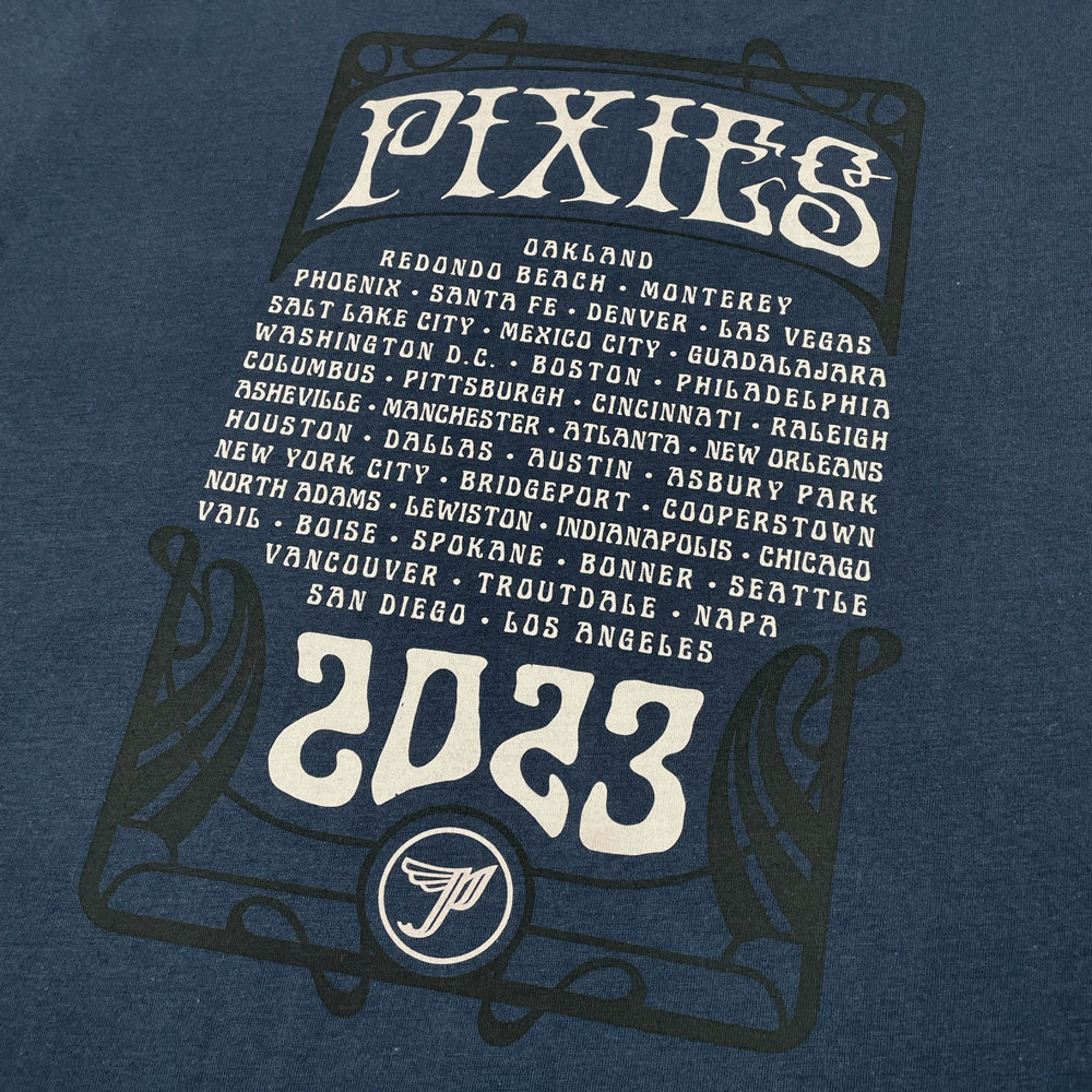 Close up of the back of a navy blue women's t-shirt with cream text reading "Pixies" above a list of all 2023 tour dates. Below is text reading "2023" and a Pixies "Circle P" logo in cream.