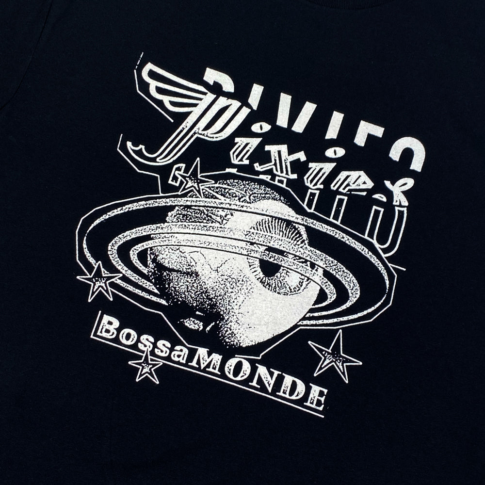 Close up of a black t shirt with white text logo reading "Pixies" followed by a white design of an eyeball with Saturn like rings and stars. Below is white text reading "Bossa Monde"