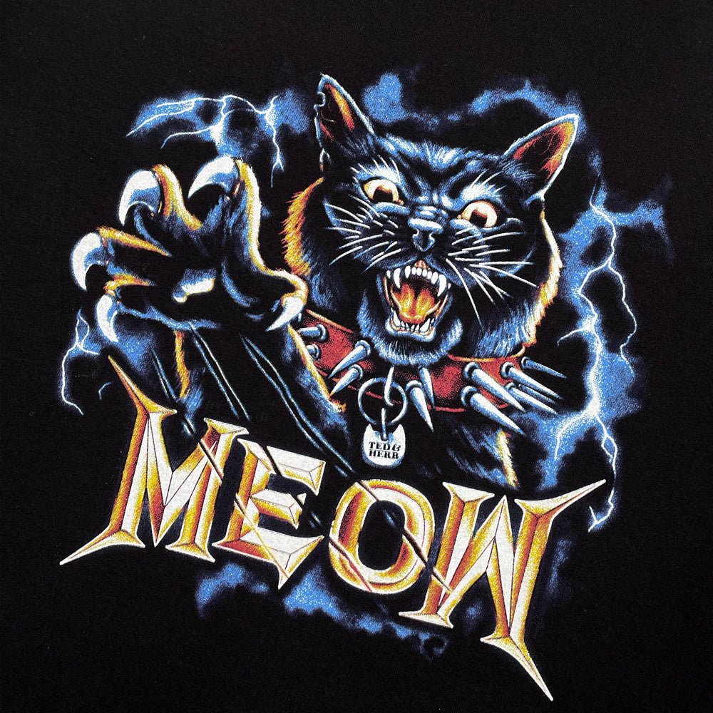 Close up of a black t-shirt with a graphic of a black cat above golden typography reading "MEOW"