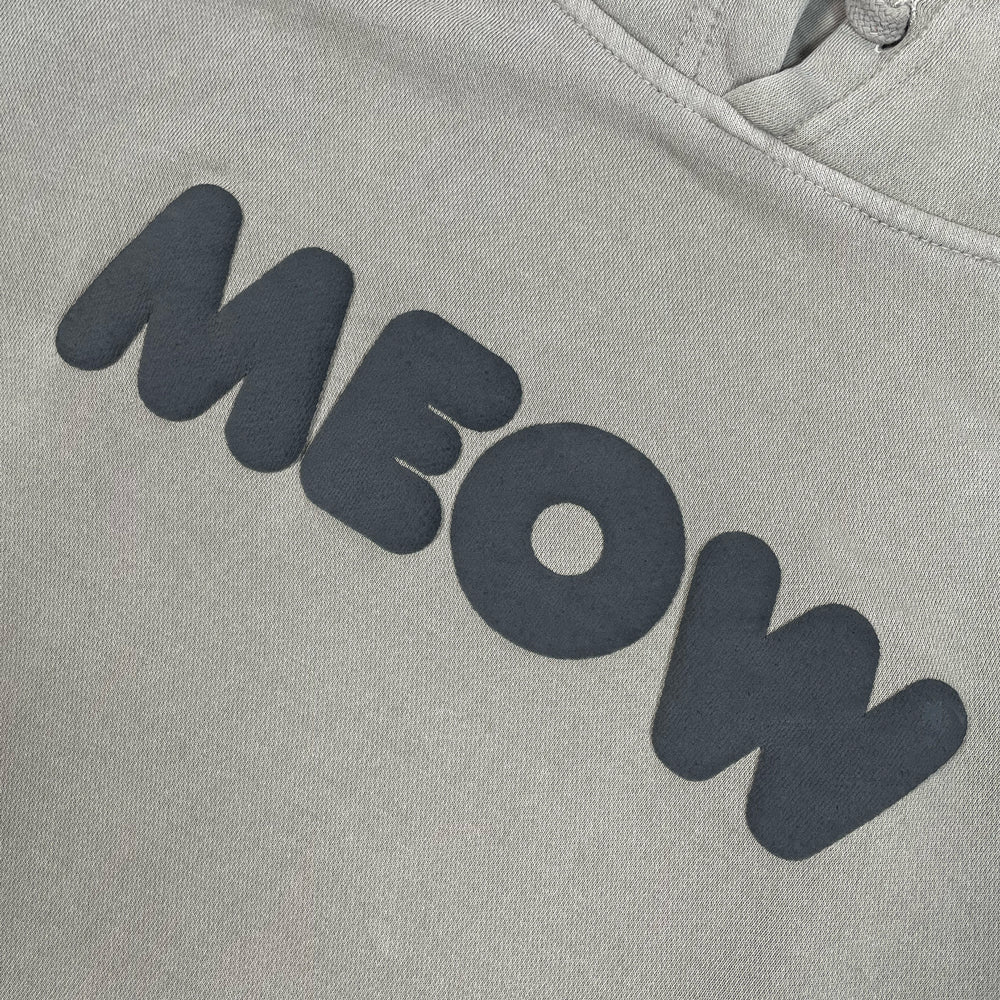 Close up of a grey hooded sweatshirt with black lettering reading "MEOW"